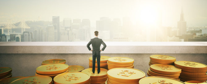 businessman standing on gold coins and looking on city