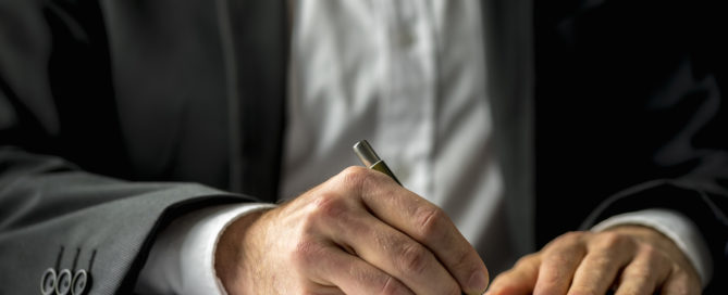 Conceptual image of a man signing a last will and testament document.